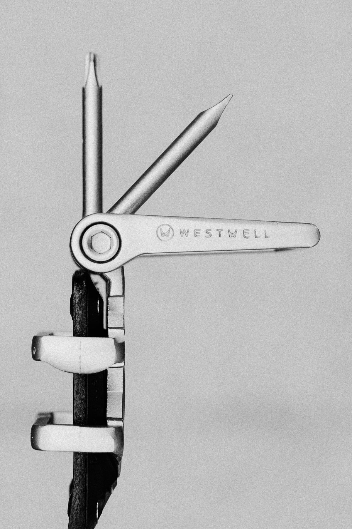 A close-up of the 686 Westwell Voyager Belt by Westwell, showing two tools extended and the brand name engraved on the handle, set against a plain background.