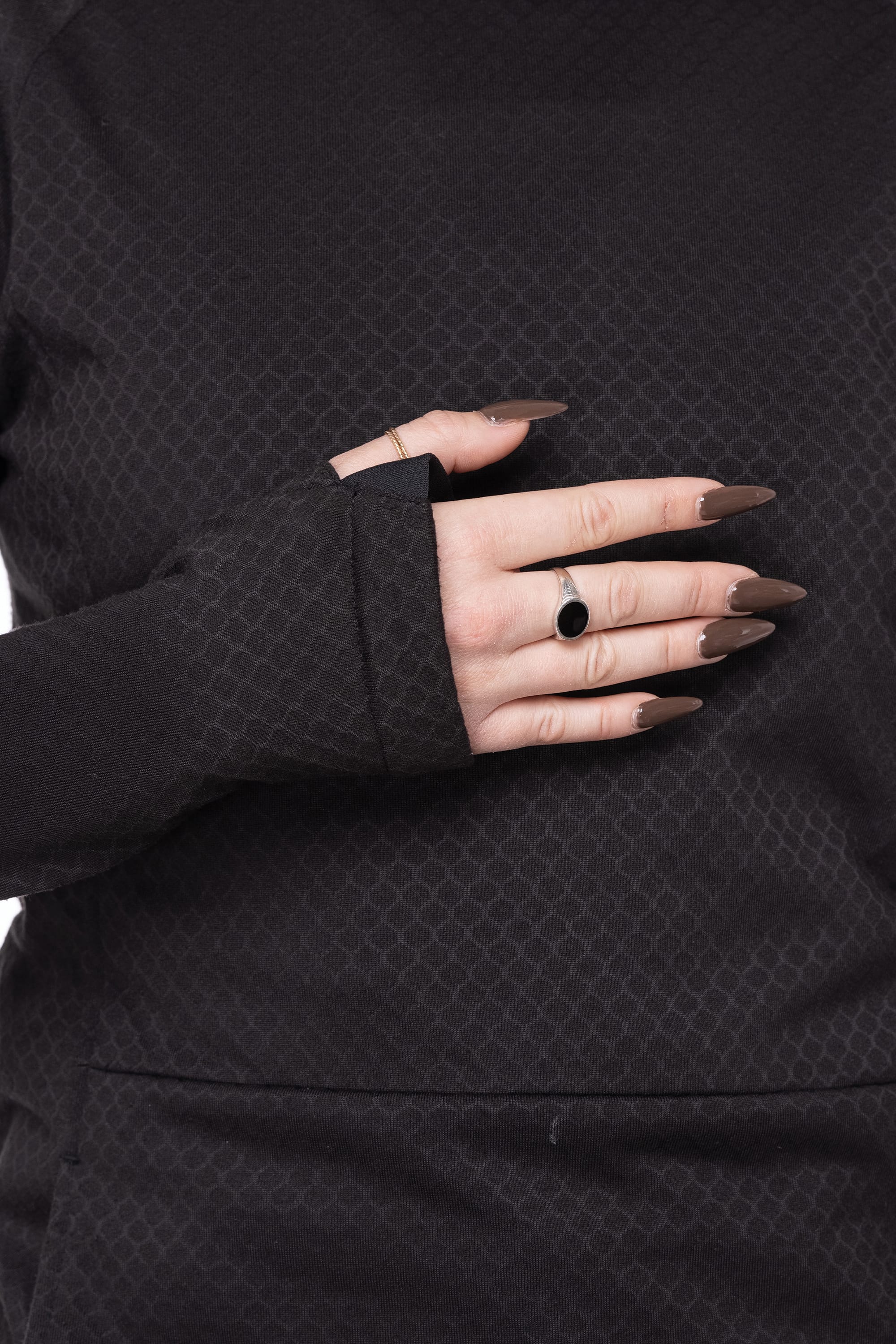 A person wearing the 686 Women's Mission Gridª Fleece Hoody rests a hand with long brown manicured nails, a black stone ring, and a thin gold band on their chest.